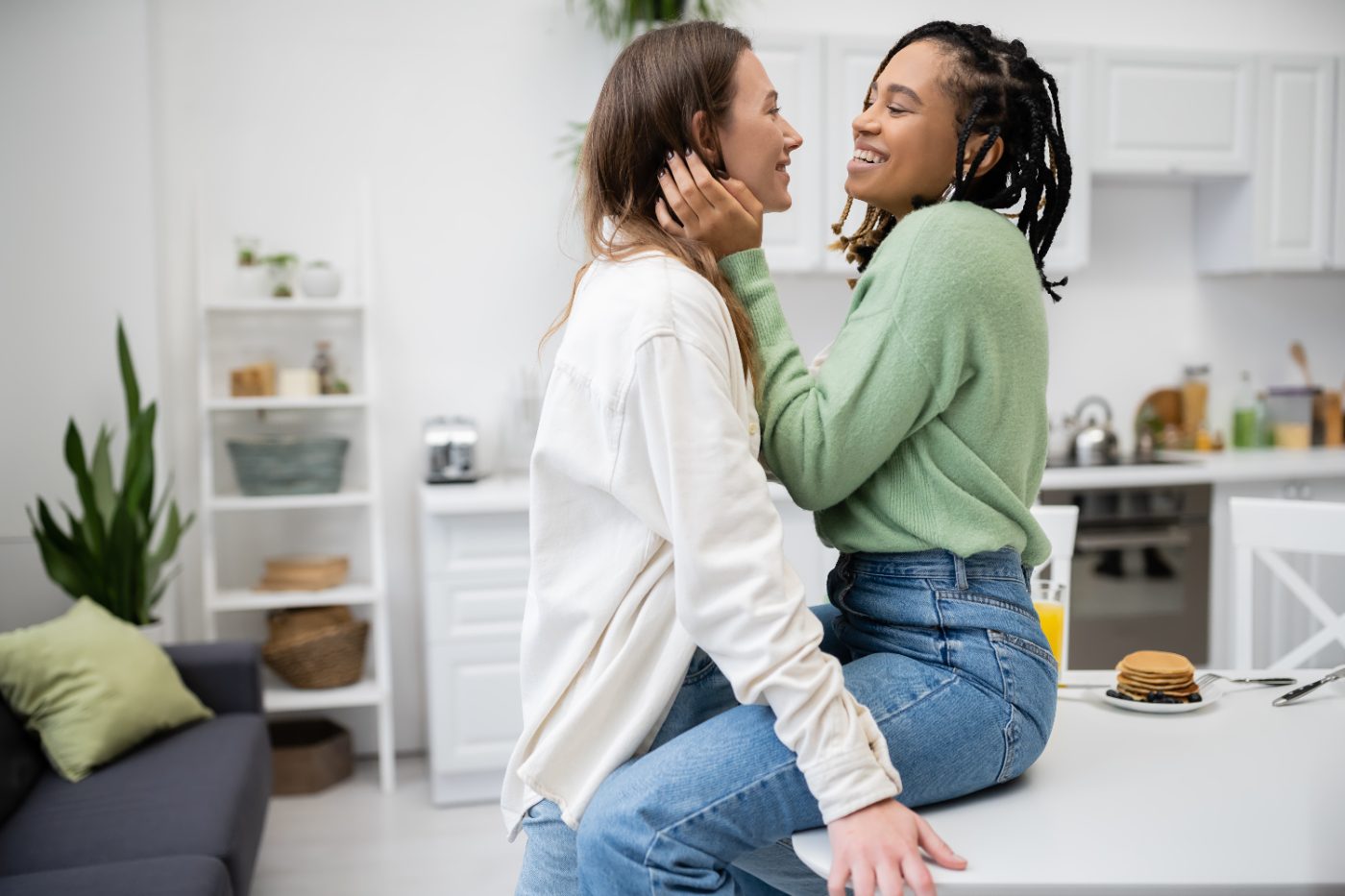 Two women smiling at each other in a bright kitchen