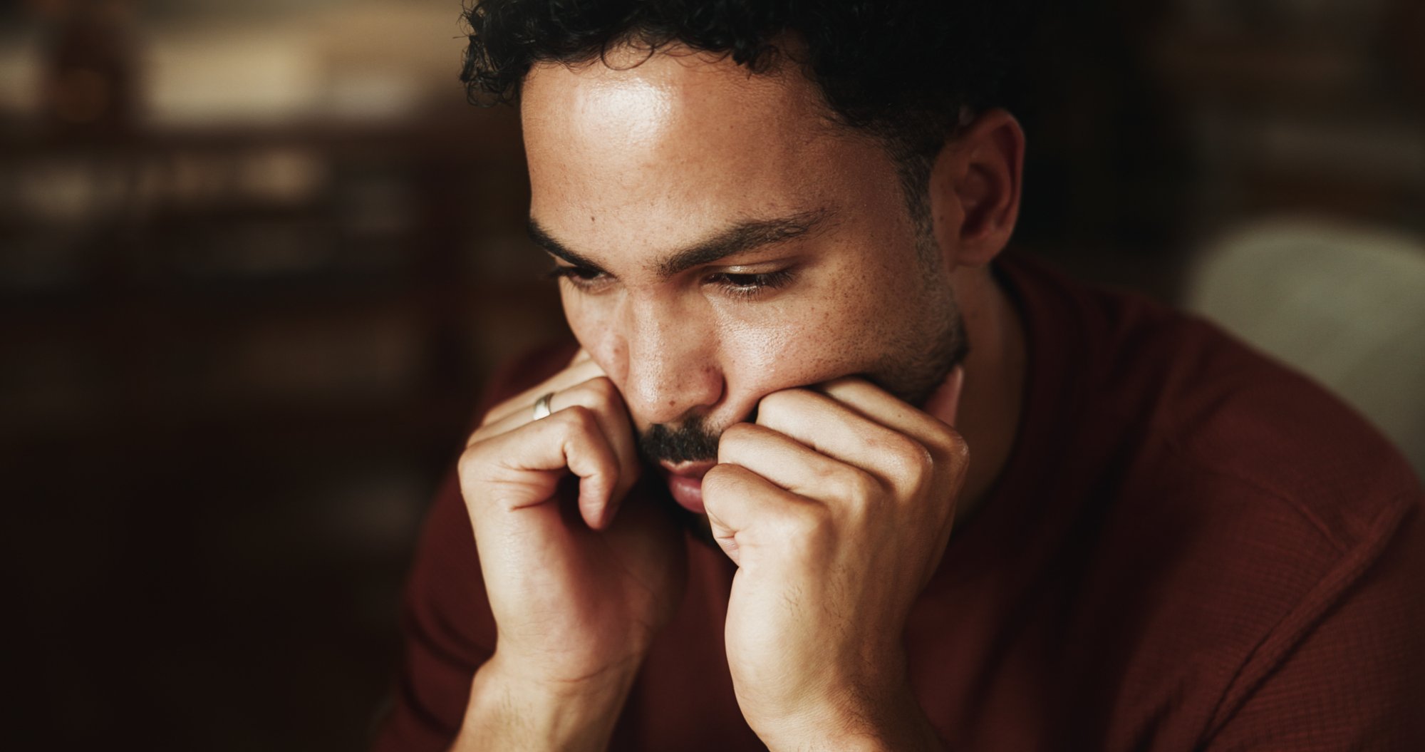 A man resting his chin on his hands, deep in thought